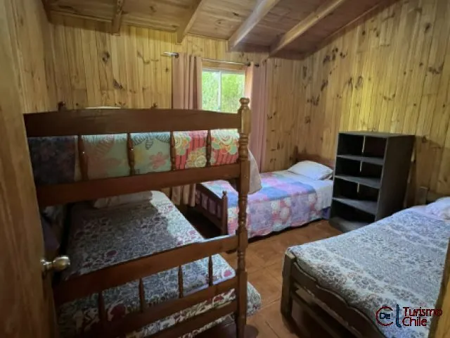 Dormitorio con camarote y camas individuales de madera en cabaña familiar Mi Casa